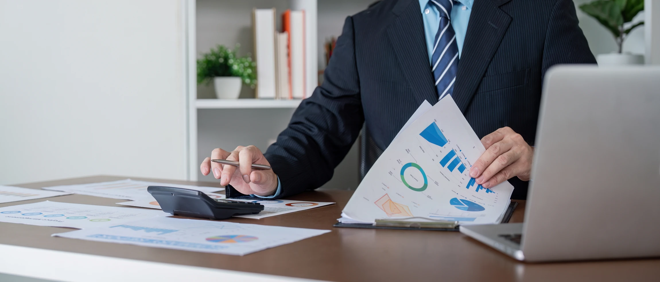 Réunion de travail en intérieur avec trois professionnels analysant des documents financiers