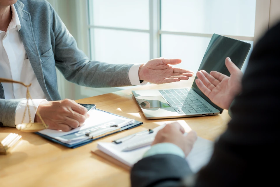 Espace de travail de bureau avec documents financiers étalés sur une surface blanche