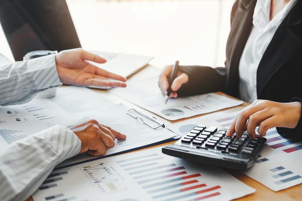 documents d'affaires sur table de bureau avec smartphone et tablette numérique et graphique financier avec diagramme de réseau social et homme travaillant en arrière-plan