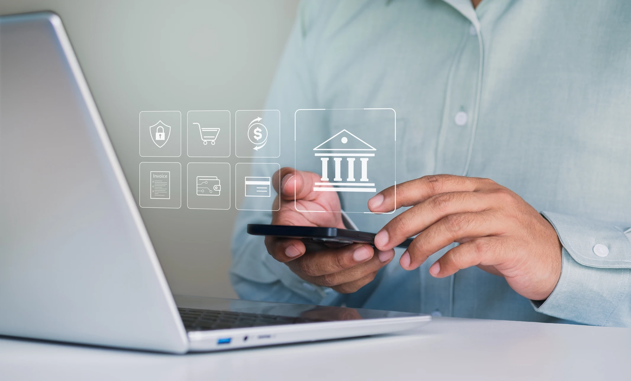 Personne travaillant sur des documents financiers dans un bureau, utilisant une calculatrice d'une main et saisissant des données sur un ordinateur portable de l'autre