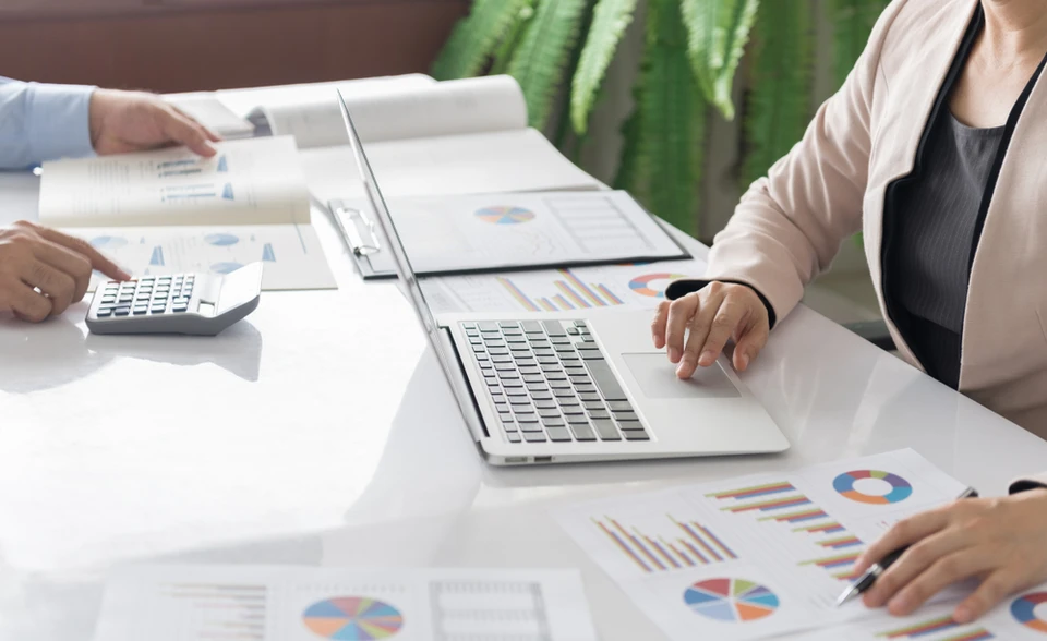 Réunion d'affaires dans un bureau moderne avec deux professionnels analysant des documents financiers
